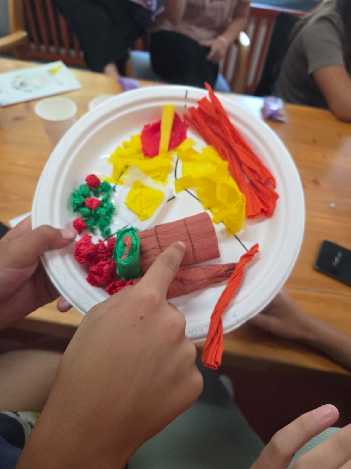 Copil arătând farfuria creativă finalizată la atelier